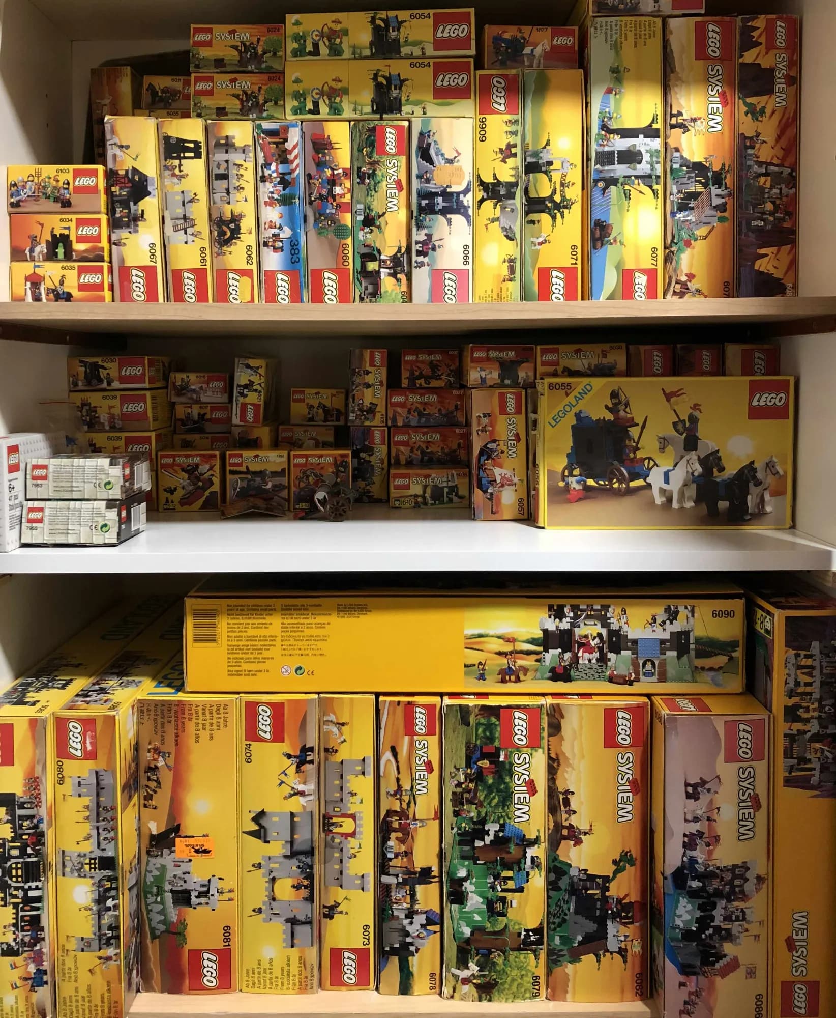 Boxes of 1980s and 1990s LEGO castle sets on the shelves of our collection